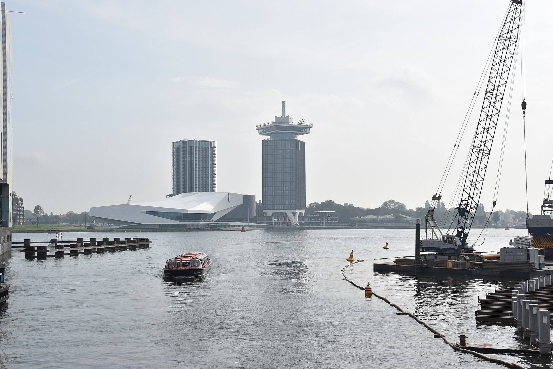 The EYE Filmmuseum at the Buiksloterweg dock - its glass-walled café faces straight back across the water.